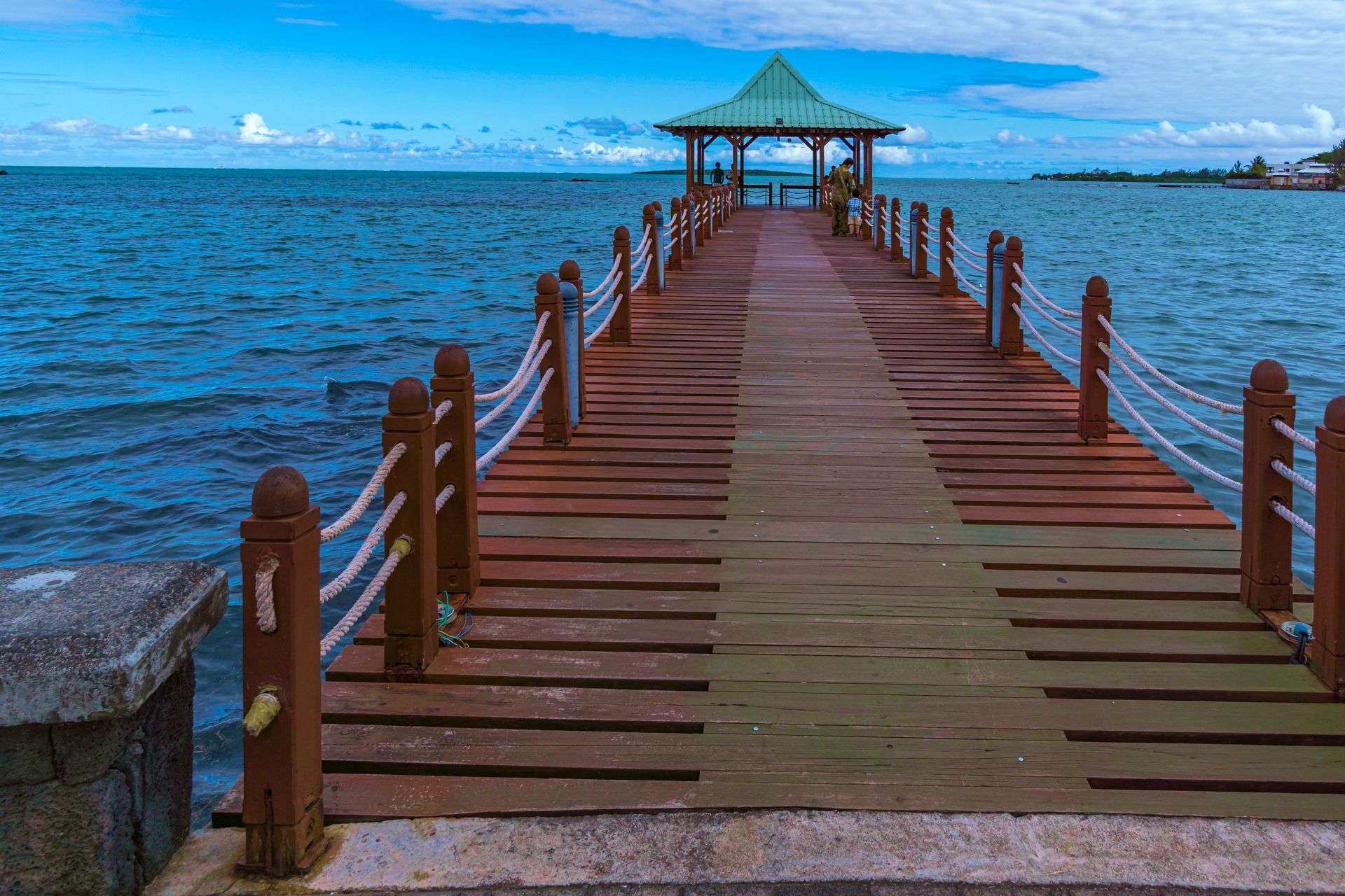 View of a wooden bridge towards a pavilion in the sea in Mahebourg, Mauritius, an Indian Ocean island nation, known for its paradisiac beaches