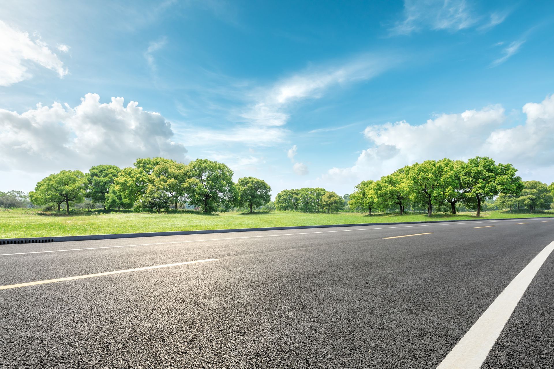 Country road and green forest natural landscape under the blue sky