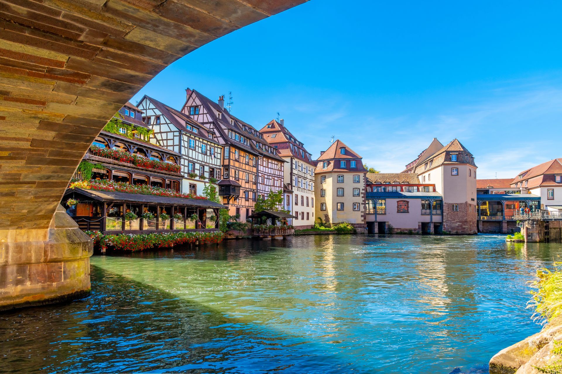 Colorful half timber buildings of shops and cafes line the canals in the Petite-France area of Strasbourg, France, in the Northeast Alsace region. 