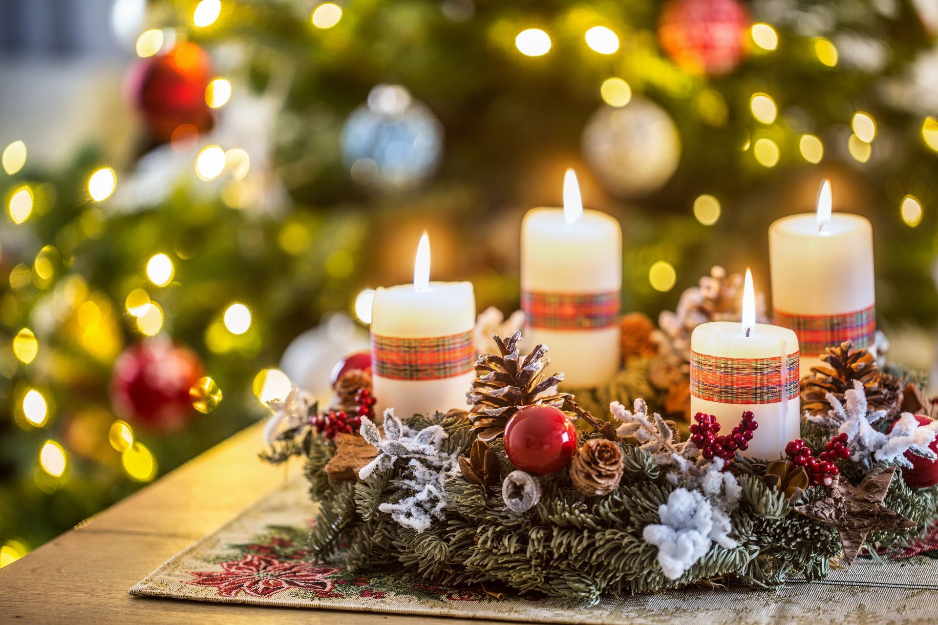 Advent wreath with four white burning candles christmas ball and decorations on a wooden background with festive atmosphere.